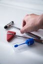 Female neurologist using reflex hammer and stool sample tube for multiple sclerosis research or examination