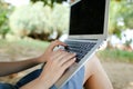 Female nice hands using laptop with sand in background, black screen. Royalty Free Stock Photo