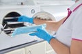 Female nurse doing sterilization of dental medical instruments in autoclave