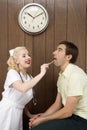 Female nurse examinating man's mouth. Royalty Free Stock Photo