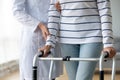 Female nurse helping old grandmother patient using walking frame, closeup Royalty Free Stock Photo