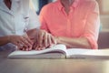 Female nurse helping patient reading the braille book Royalty Free Stock Photo