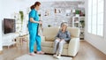 Female nurse helping senior woman getting dressed Royalty Free Stock Photo