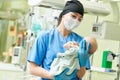 Newborn baby in hospital at neonatal resuscitation center with nurse