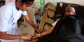 A female nurse injecting needle into the patient hand during treatment