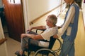 Female nurse pushing disabled senior male patient sitting in wheelchair Royalty Free Stock Photo