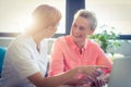 Female nurse and senior woman smiling while using laptop Royalty Free Stock Photo