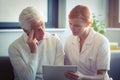 Female nurse showing medical report to senior man on digital tablet Royalty Free Stock Photo