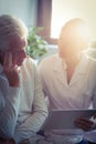 Female nurse showing medical report to senior man on digital tablet Royalty Free Stock Photo