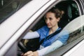 Female nurse sitting in car, going home from work. Female doctor driving car to work, on-call duty. Work-life balance of Royalty Free Stock Photo