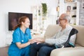 Female nurse smiling and talking with elderly age man Royalty Free Stock Photo