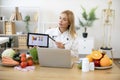 Female nutritionist explaining details of slimming program for client online. Royalty Free Stock Photo