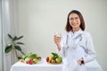 Female nutritionist showing milk glass at her office