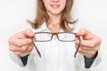 Female oculist doctor giving glasses to patient