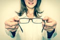 Female oculist doctor giving glasses to patient - retro style Royalty Free Stock Photo