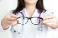 Female oculist doctor's hands giving a pair of black glasses Royalty Free Stock Photo