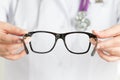 Female oculist doctor's hands giving a pair of black glasses Royalty Free Stock Photo
