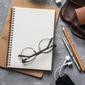 Female office desk with notepad, tablet, leather bag, glasses, earphones. On a gray background, top view. Copy space