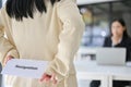 A female office worker hiding a resignation letter behind her back while talking with her boss Royalty Free Stock Photo