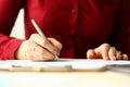 Female office worker holding silver pen filling out some application form