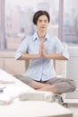 Female office worker meditating at work Royalty Free Stock Photo