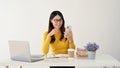 A female office worker is reading a message on her smartphone while sitting at her desk Royalty Free Stock Photo