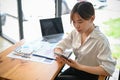 Female office worker sitting at the table and using her cellphone in the office Royalty Free Stock Photo