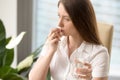 Female office worker takes medication at work Royalty Free Stock Photo