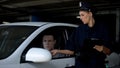 Female officer giving traffic ticket to male driver for parking violation, fine Royalty Free Stock Photo