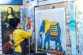 A female oil painting artist painting on a canvas in the Dafen Oil painting village, Shenzhen, Guangdong province, China Royalty Free Stock Photo