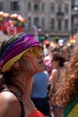 Female onlooker with LGBT rainbow painted face and headscarf watching the Gay Pride Parade, London 2018.