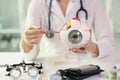 Female ophthalmologist shows an anatomical model of human eye while sitting at table in clinic. Royalty Free Stock Photo