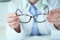 Female optician hands giving new glasses to customer for testing and trying close-up. Eye doctor with client comparing Royalty Free Stock Photo