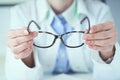 Female optician hands giving new glasses to customer for testing and trying close-up. Eye doctor with client comparing Royalty Free Stock Photo