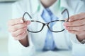 Female optician hands giving new glasses to customer for testing and trying close-up. Eye doctor with client comparing Royalty Free Stock Photo