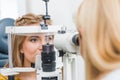 female optometrist examining patient through slit lamp Royalty Free Stock Photo