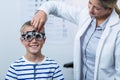 Female optometrist examining young patient with phoropter Royalty Free Stock Photo