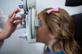 Female optometrist examining young patient on phoropter Royalty Free Stock Photo