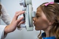 Female optometrist examining young patient on phoropter Royalty Free Stock Photo