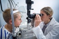 Female optometrist examining young patient on slit lamp Royalty Free Stock Photo