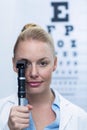 Female optometrist looking through ophthalmoscope