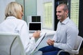Female optometrist talking to male patient