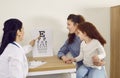 Female optometrist with test chart checks kid eye sight who came to reception together with mom. Royalty Free Stock Photo