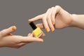 Female with orange nail design. Glitter orange nail polish manicure with red nail art. Woman hands hold yellow nail polish bottle Royalty Free Stock Photo