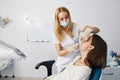 Dentist putting putty stone into patient mouth for dental impression