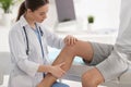 Female orthopedist examining patient`s leg in clinic Royalty Free Stock Photo