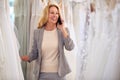 Female Owner Of Bridal Wedding Dress Shop Talking On Mobile Phone Royalty Free Stock Photo