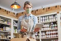 Female Owner Delicatessen With Digital Tablet Wearing Face Mask Preparing Online Grocery Order