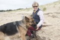 Female owner giving pet Alsatian a drink of water on a hot sunny day Royalty Free Stock Photo