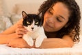 Female owner holding her black and white cat in the bedroom. Con Royalty Free Stock Photo